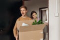 Positive curious surprised students with open mouth taking cardboard boxes, enter campus room. New apartment for college Royalty Free Stock Photo