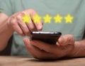 Positive customer experience concept. Phone user review and rating on mobile phone. Smartphone in male hands and 5 star