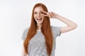 Positive cute young tender redhead girlfriend smiling excited joyfully glance camera show peace victory gesture