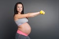 Positive delighted pregnant woman with dumbbells Royalty Free Stock Photo