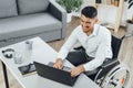 Positive disabled young man in wheelchair working in office Royalty Free Stock Photo
