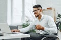 Positive disabled young man in wheelchair working in office Royalty Free Stock Photo