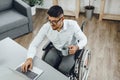 Positive disabled young man in wheelchair working in office Royalty Free Stock Photo
