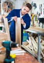 Man measuring boards for furniture at workshop