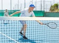 Elderly male player serving ball during training tennis in court outdoors Royalty Free Stock Photo