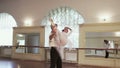 Positive elegant couple practices ballet moves in studio, slowmo