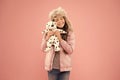 Positive emotions. Happy small smiling child play with soft dog on pink background. Happy little child hold play toy