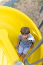 Positive emotions. View from above. Portrait of laughing happy boy coming down slide . Royalty Free Stock Photo