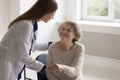 Positive empathetic doctor woman giving comfort to elderly patient Royalty Free Stock Photo