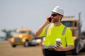 positive employee construction man in vest protective hardhat talk on phone with lunch outdoor, copy space. construction