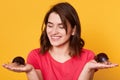 Positive European woman with giant Achatina snails, has dark hair holds her favourite pets, dressed in casual pink t shirt, being