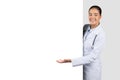Positive european young lady doctor in white coat point hand on huge banner with empty space