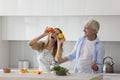 Positive excited adult daughter and senior father dancing in kitchen Royalty Free Stock Photo