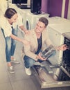 Positive family couple looking at dishwashers Royalty Free Stock Photo