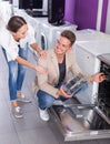 Positive family couple looking at dishwashers Royalty Free Stock Photo