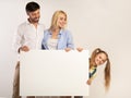 Family Holding White Board For Text Standing On White Background