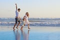 Positive family running along sea edge on the beach