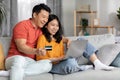 Positive family shopping from home, using notebook and credit card Royalty Free Stock Photo