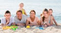 Positive family of six people lying together on beach