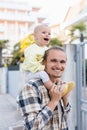 Positive father holding cheerful daughter on