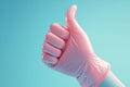 Positive feedback gesture Pink gloved hand showing a like on blue