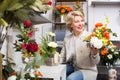 Positive female customer choosing flowers