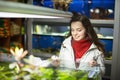 Positive female customer watching fish in aquarium tank Royalty Free Stock Photo