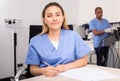 Positive female doctor cosmetologist filling medical forms Royalty Free Stock Photo