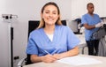 Positive female doctor cosmetologist filling medical forms Royalty Free Stock Photo