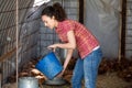 Positive female farmer giving feeding stuff