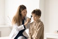 Female doctor examining boy ear with otoscope Royalty Free Stock Photo