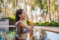 Positive female tasting juice in swimming pool Royalty Free Stock Photo