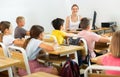 Positive female teacher giving lesson for primary school pupils Royalty Free Stock Photo
