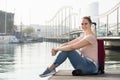 Positive female tourist standing at pier in cold spring day Royalty Free Stock Photo