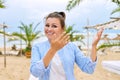 Positive female travel consultant at seaside resort looking talking to webcam Royalty Free Stock Photo
