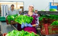 Positive female vegetable factory worker demonstrating lettuce while sorting