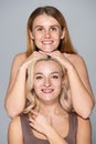 Positive freckled woman posing near friend