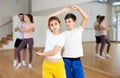 Teen sister and brother learning to dance waltz in pair in studio Royalty Free Stock Photo