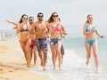 Positive friends running in swimwear