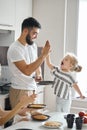 Positive funny daddy and his kid giving high five to each other