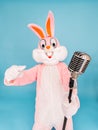 Positive funny man or kid singer or vocalist sings song to retro vintage classic microphone. Easter bunny or rabbit or