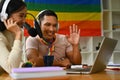 Positive gay male podcaster and friend speaking into microphone, live streaming event, sharing experience