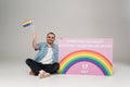 Positive gay man holding lgbt flag