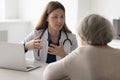 Positive geriatrician doctor woman talking to elderly patient Royalty Free Stock Photo