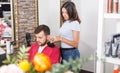 Girl hairdresser cuts hair of young man client at beauty salon Royalty Free Stock Photo