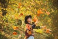 Positive girl model resting. Autumn leaves falling on happy young woman in forest. Fall concept. Autumn woman in autumn Royalty Free Stock Photo