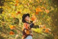 Positive girl model resting. Autumn leaves falling on happy young woman in forest. Fall concept. Autumn woman in autumn Royalty Free Stock Photo