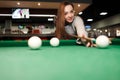 Positive girl plays billiards at leisure Royalty Free Stock Photo