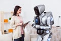 Positive girl standing with the robot Royalty Free Stock Photo