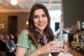 Positive girl taking a break sitting at bar in the cafe shop Royalty Free Stock Photo